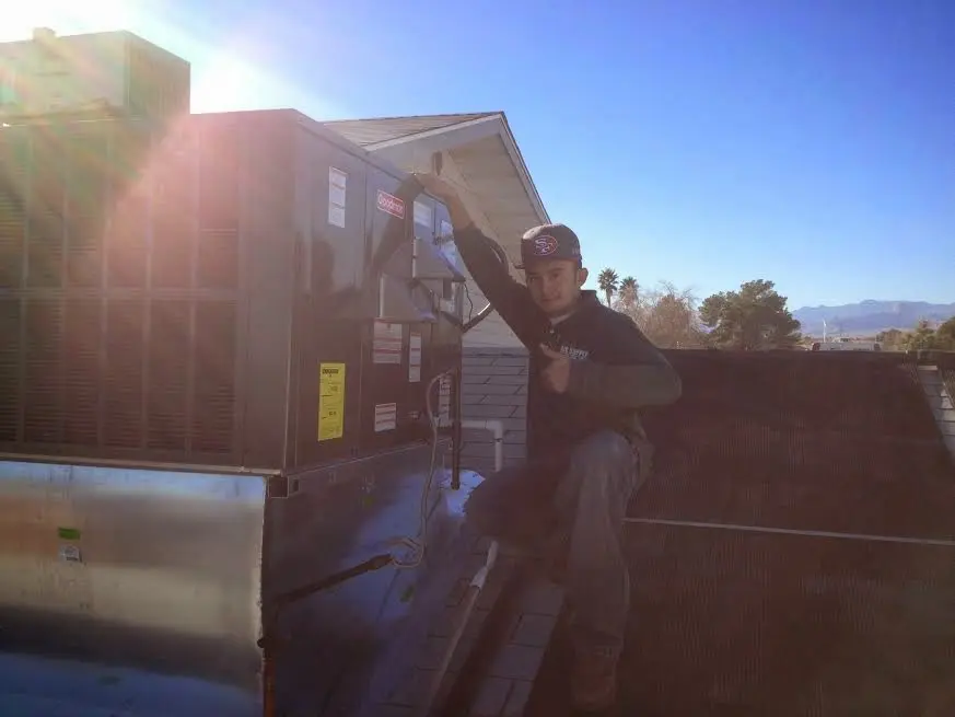 HVAC technician performing AC Tune-Up on a rooftop unit in Portland